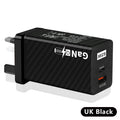 Compact black 65W GaN USB-C laptop charger with interchangeable EU UK US plug heads shown alongside scale