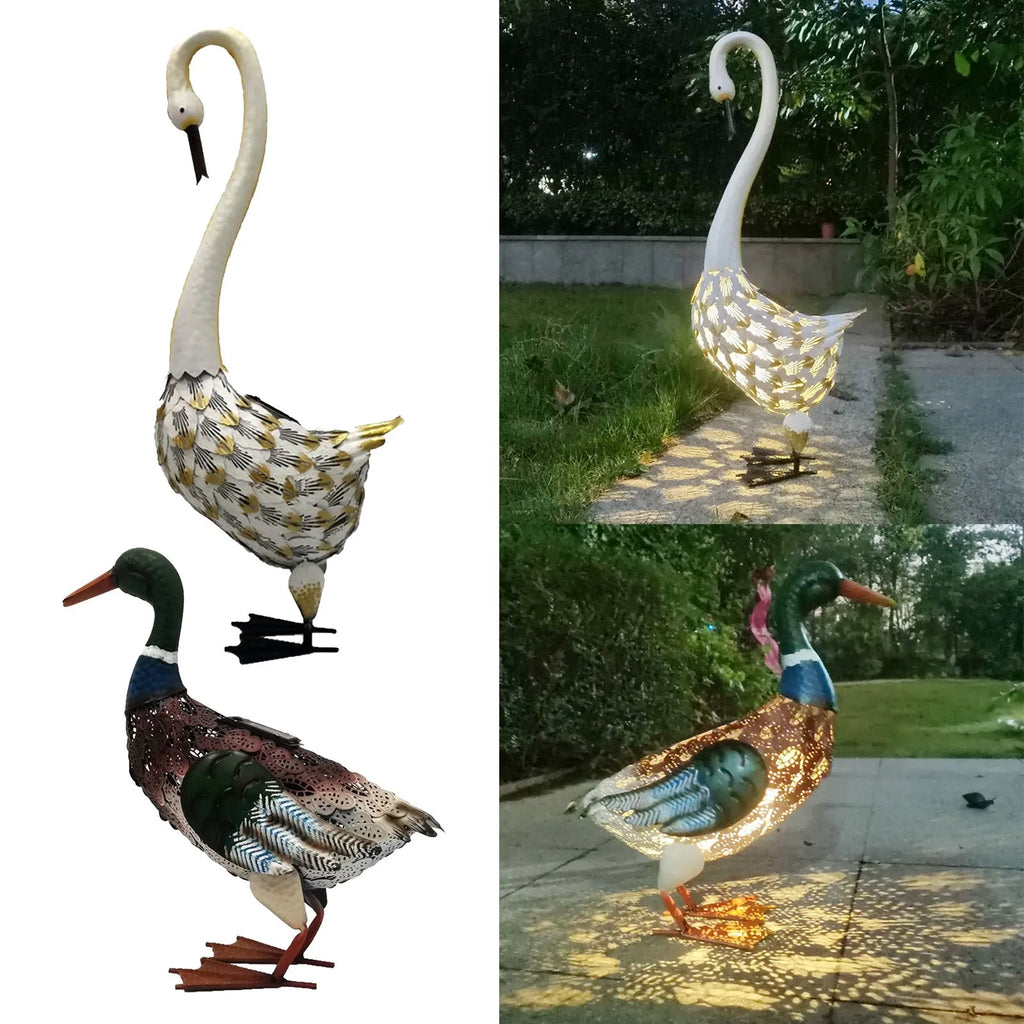 Iron wrought swan solar garden light on lawn at dusk with warm white glow