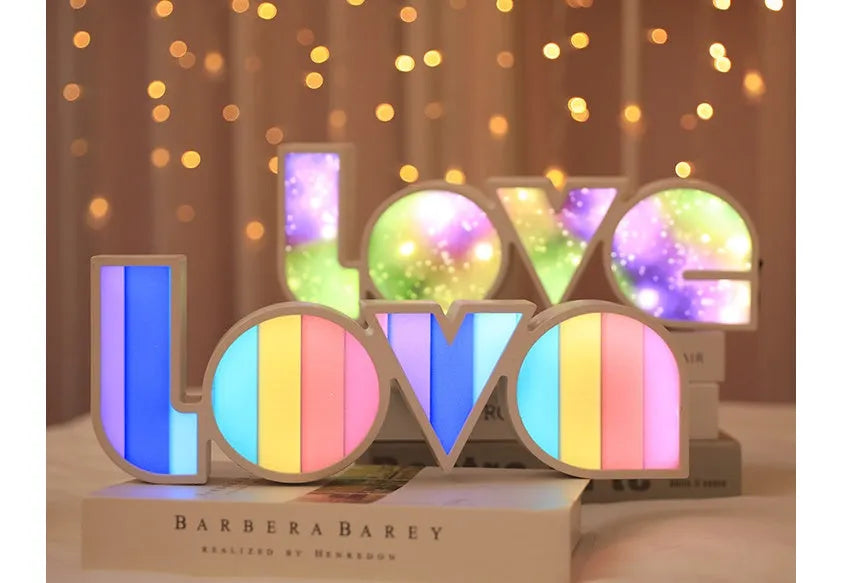 Rainbow-style plastic LED decorative light spelling LOVE, shown on a table.