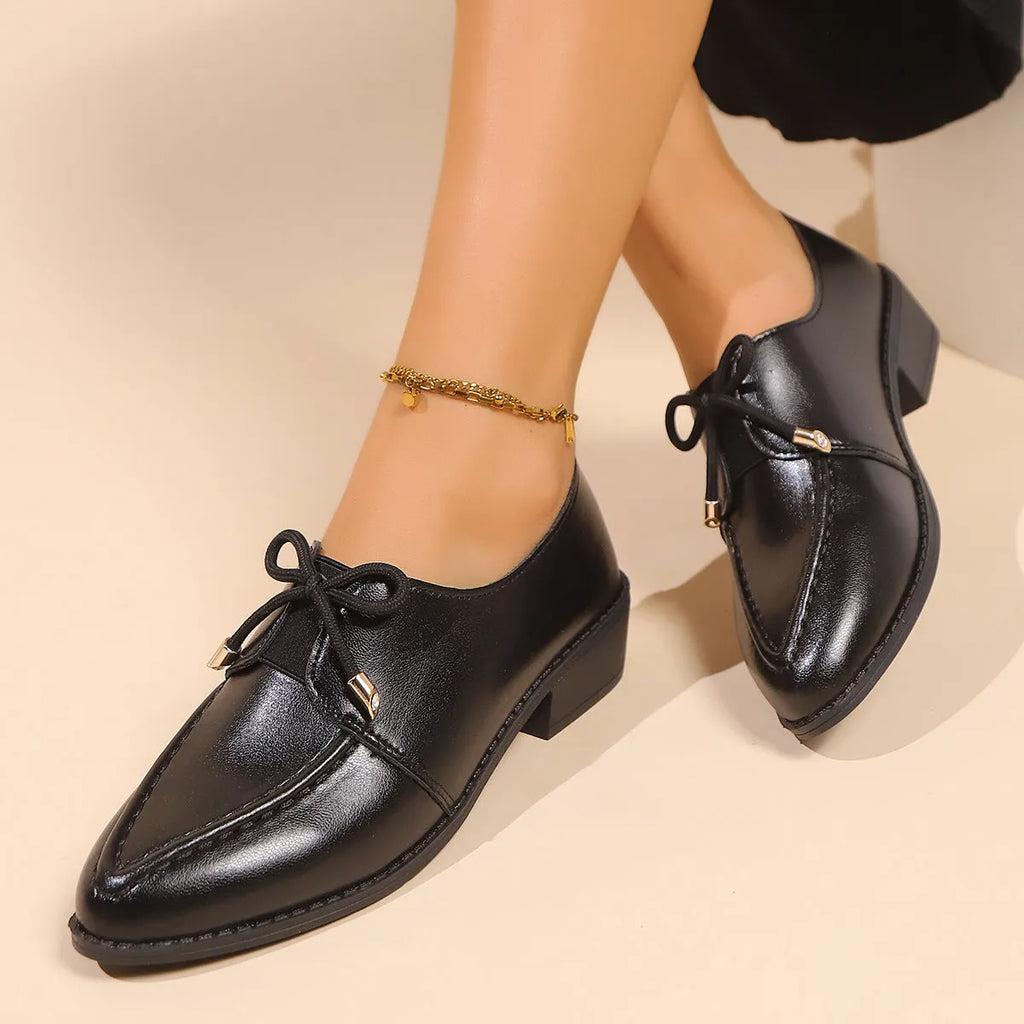 Women's simple slip-on shoe in a British-style leather look with a choice of buckle or bow decoration on the upper.
