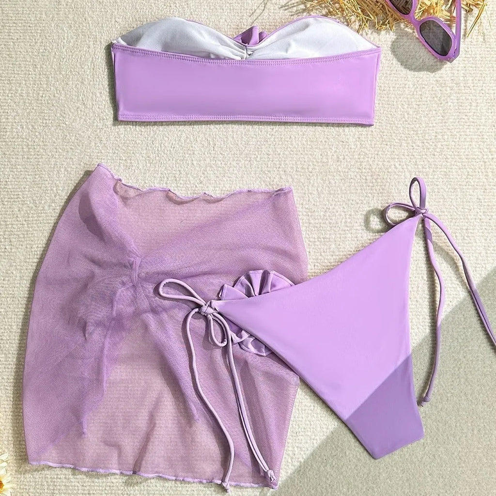 Women's pink bikini set with flower detail on tube top and a separate matching skirt.