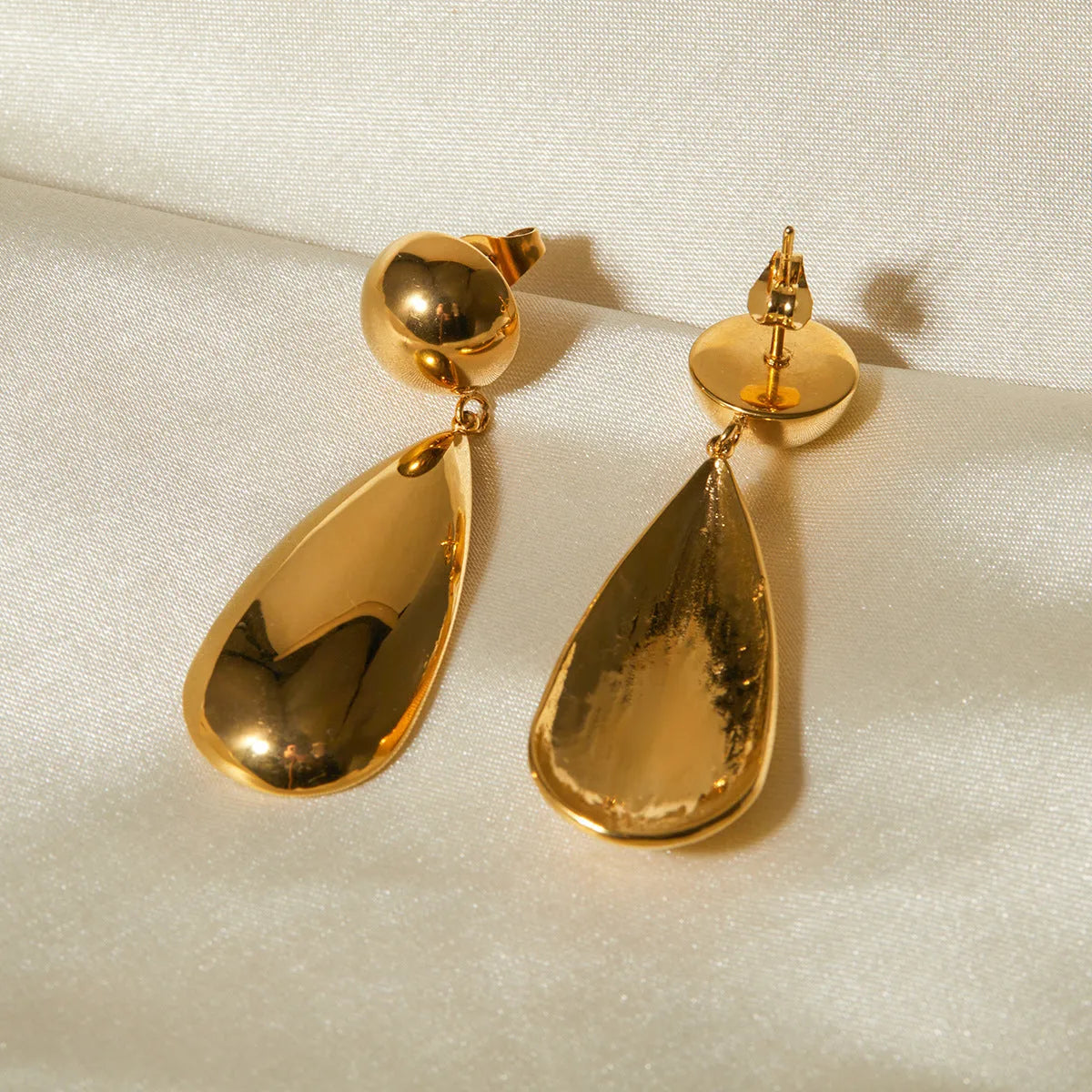 Gold stainless steel water drop shaped hemisphere pendant earrings for women.