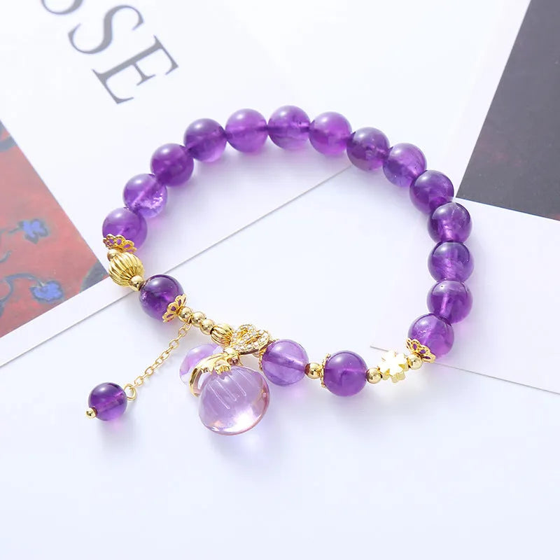 Purple amethyst bracelet with ethnic-style money bag pendant and geometric shapes on wrist