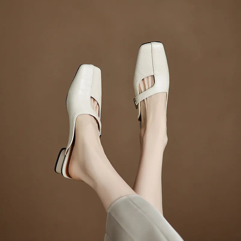 A pair of casual square-toe low-heel slippers in a solid colour on a rubber sole.