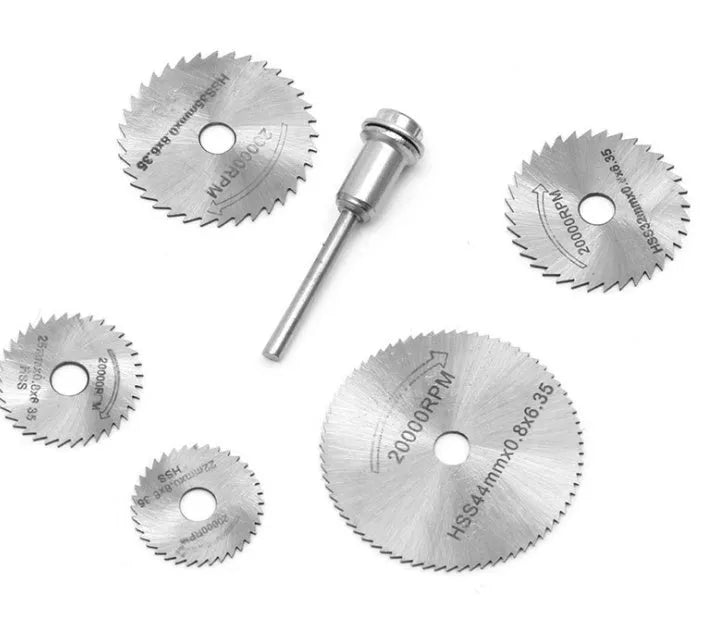 Six high-speed steel circular saw blades and a mandrel arranged on a surface, showing size variation.
