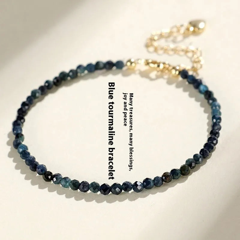 Blue tourmaline gemstone bracelet with 3mm beads and gold spacer details.