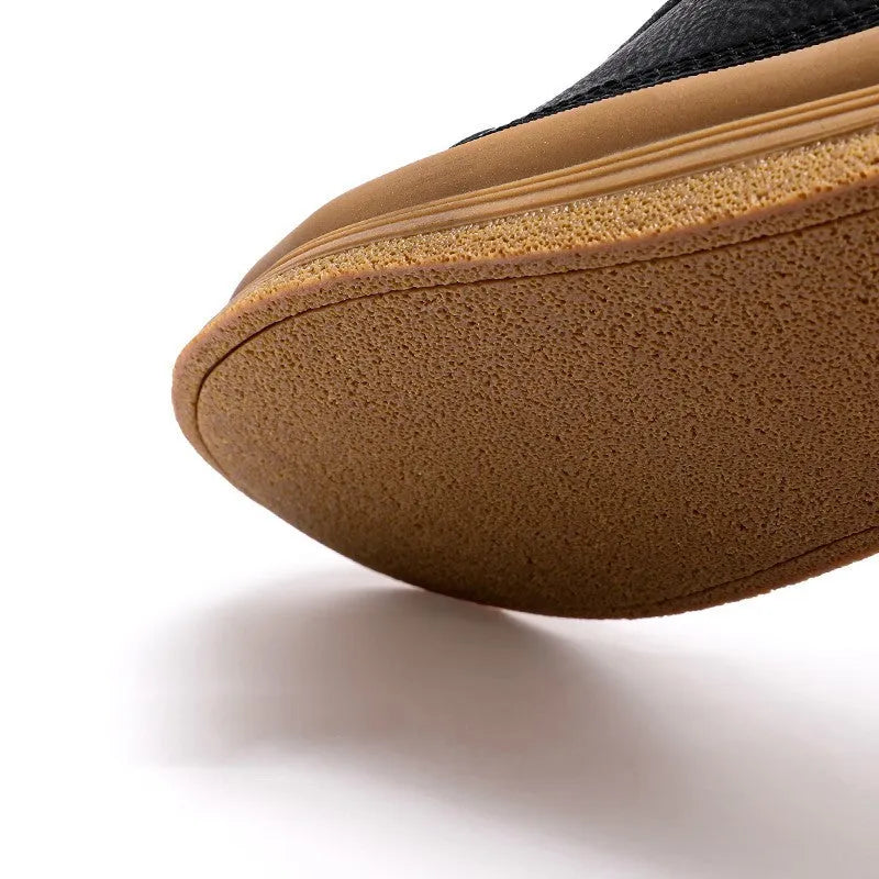 A pair of black men's round-toe casual leather shoes with white laces on a flat rubber sole.