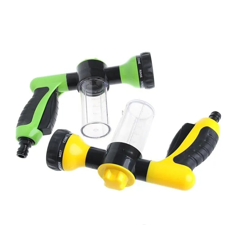 Green high-pressure foam spray gun with adjustable nozzle and connected water hose for car and garden cleaning.