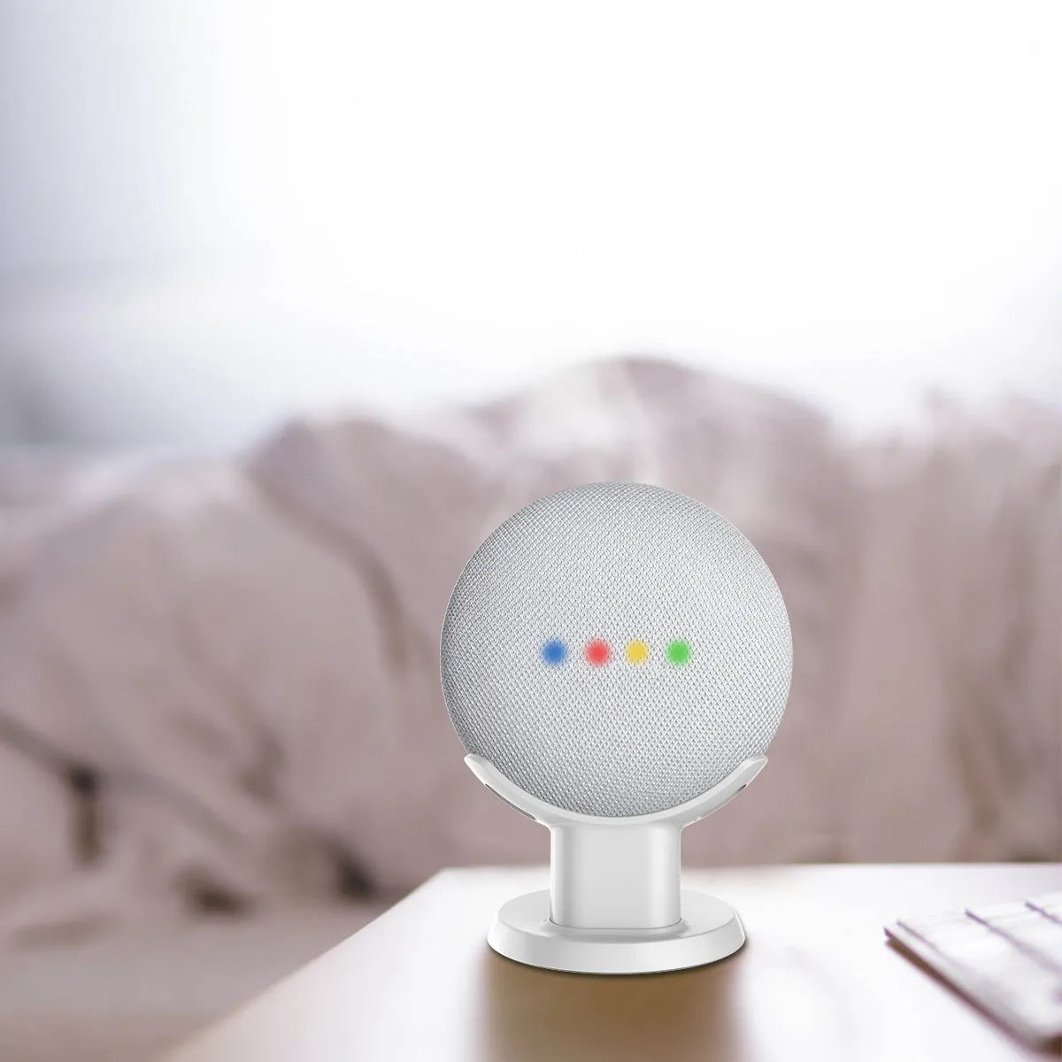 Black plastic Google Home Mini stand holder on a wooden desk