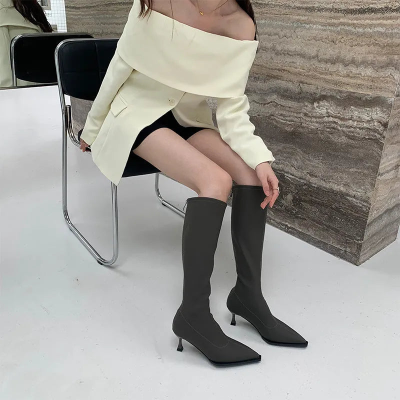 Black pointed toe women's ankle boots with a stiletto heel and a back zipper closure.