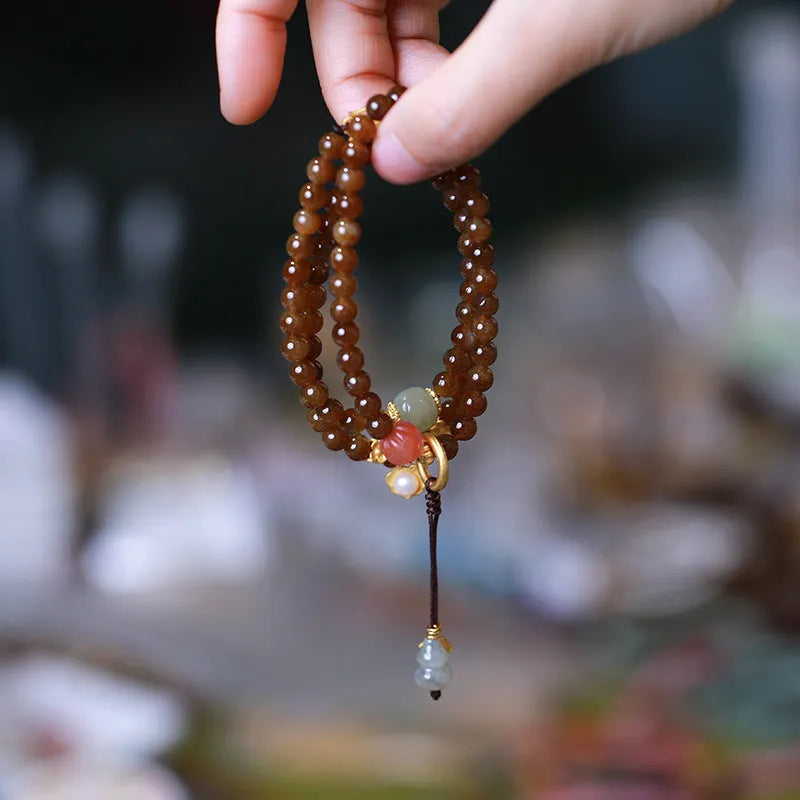 Brown Jade Hetian jade bracelet with butterfly, gourd, and pearl three-ring design and silver-plated fittings.