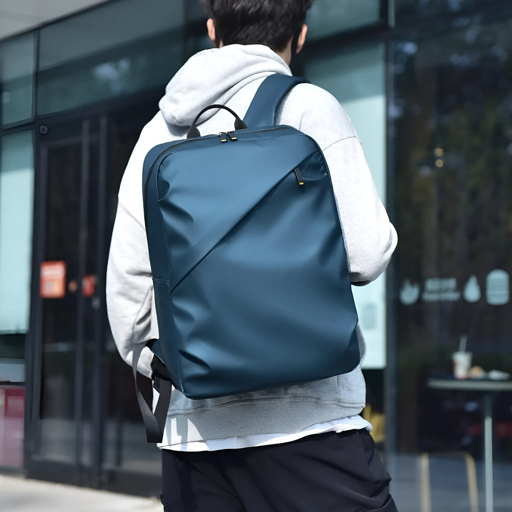 Large black waterproof PU leather computer backpack with simple design and sewing thread detailing