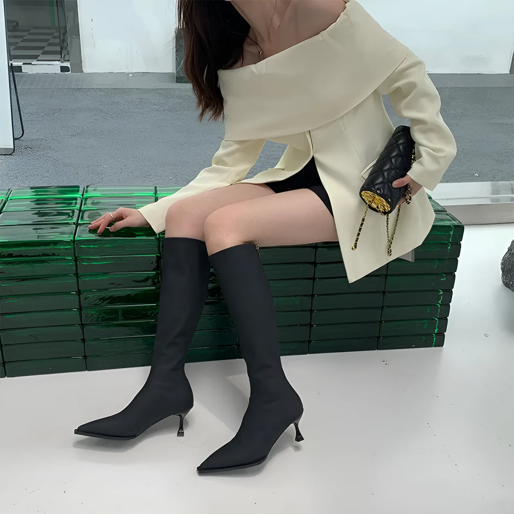 Black pointed toe women's ankle boots with a stiletto heel and a back zipper closure.