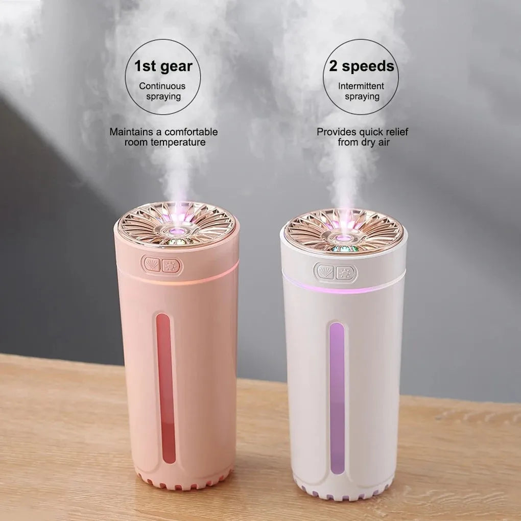 Black portable ultrasonic humidifier with colourful LED lights on a car cup holder.