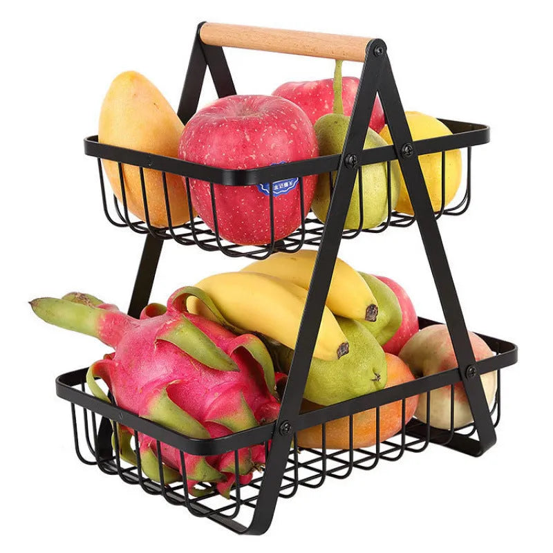 Black detachable double-layer iron fruit basket with a wooden carry handle on a tabletop.