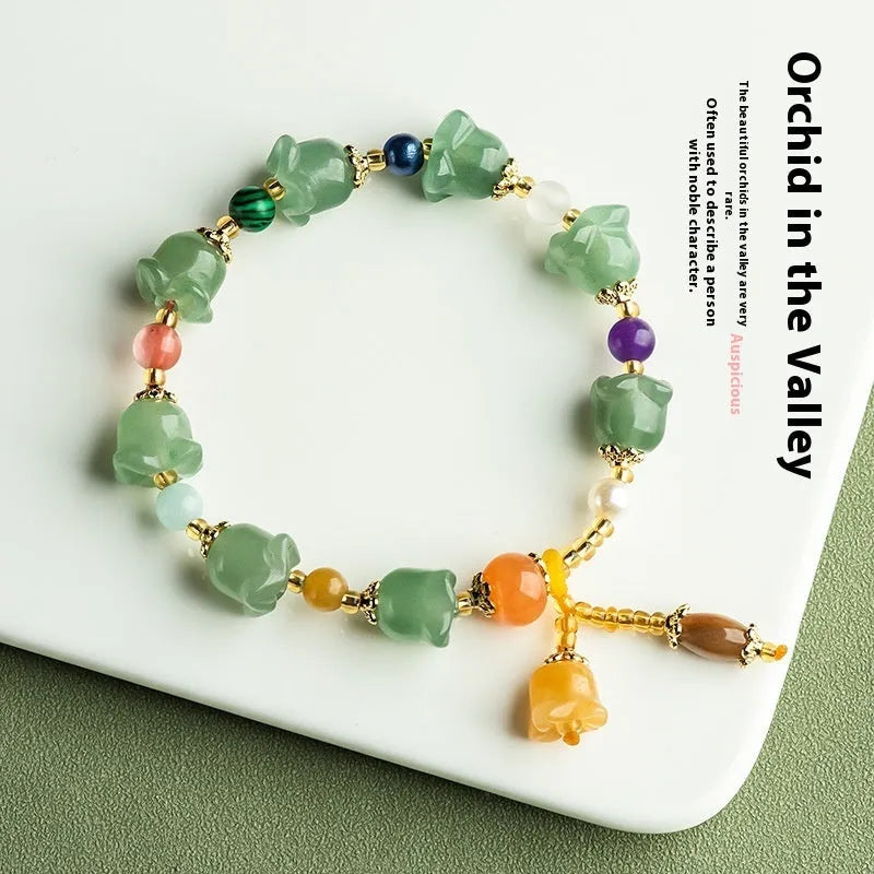 Natural Xinjiang Jinsi Jade aventurine orchid bracelet with carved orchid beads on a wrist.
