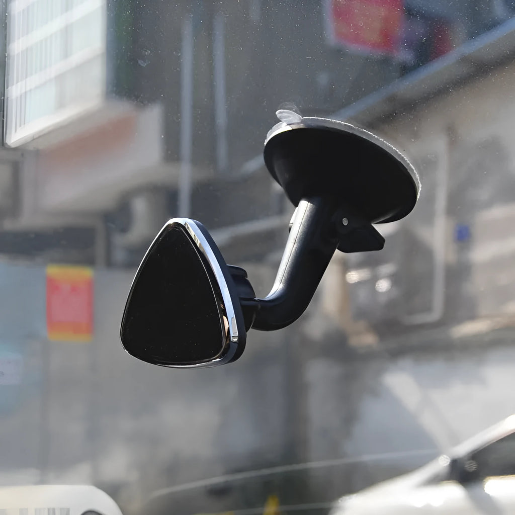 Black magnetic car phone holder mounted on a dashboard, showing a smartphone attached at an angle.