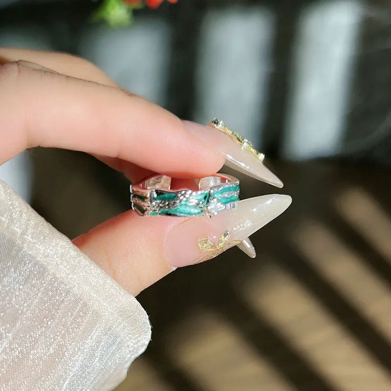 Mint green enamel asterism ring with copper base and eight-point star pattern on finger