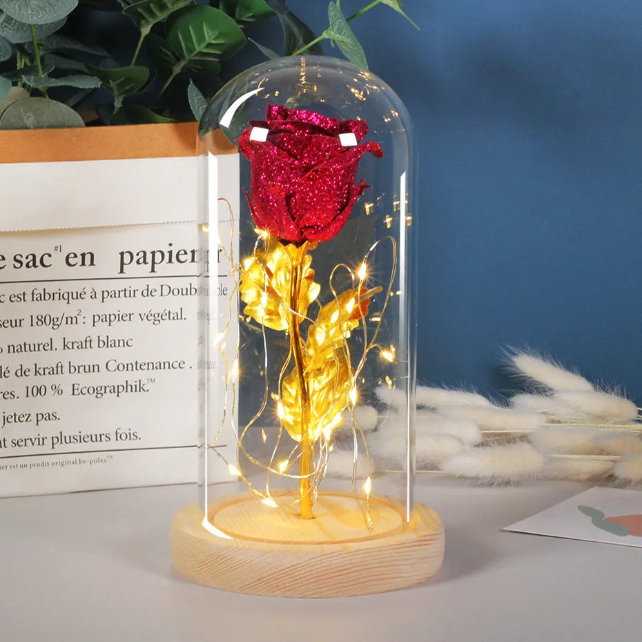 Red eternal rose in glass dome with warm white LED light string on bendable copper wire