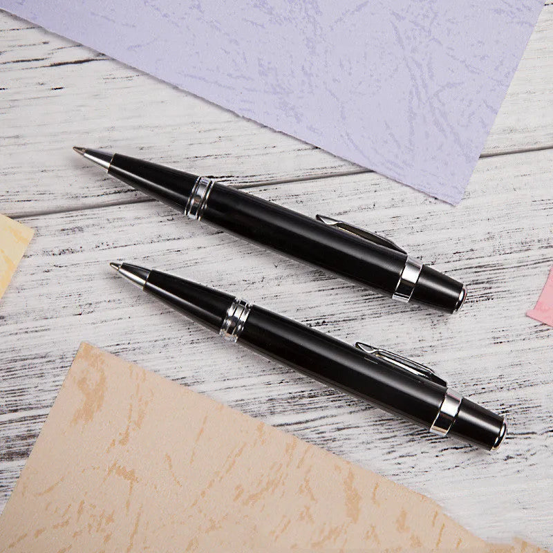 Short black metal ballpoint pen with rotating mechanism, showing bullet tip and compact dimensions