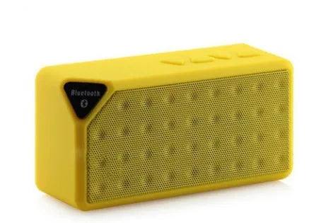 Small cube-shaped Cannon X3 portable Bluetooth speaker in multiple colour options on a table.