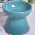 A black ceramic pet bowl with a chin-high foot and a choice of flat or slanted rim.