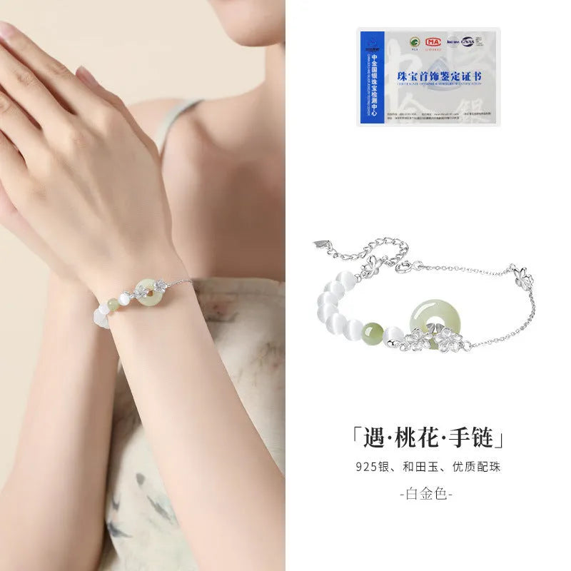 Women's pure silver bracelet with a safety buckle and a peach blossom flower charm in a choice of gold colours.