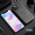 Black business leather phone case for iPhone 12 with PU leather and TPU frame on a wooden desk.