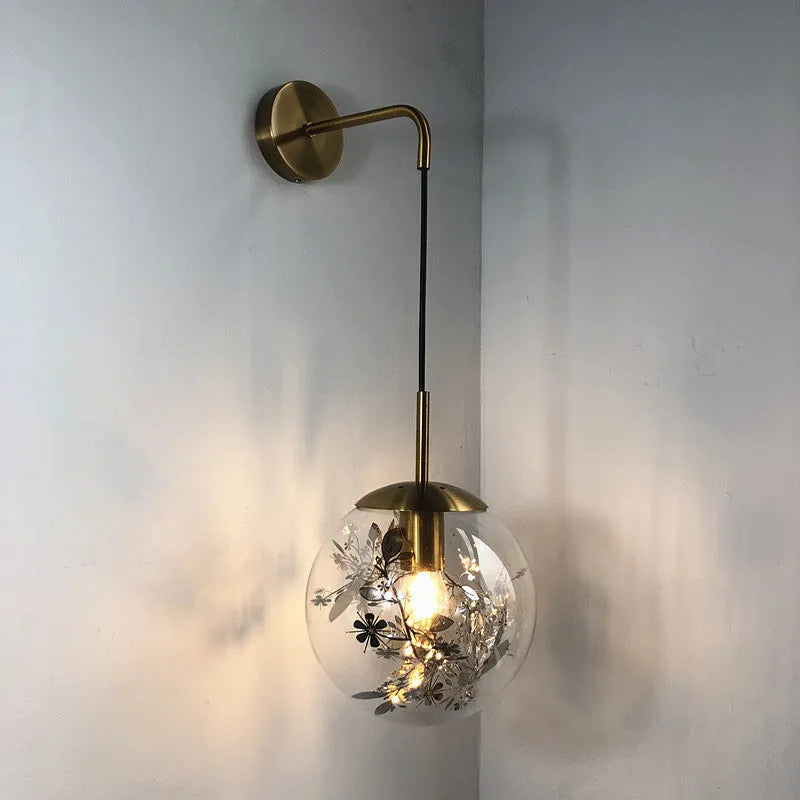 Modern glass wall lamp with golden flower finish and warm white LED light.