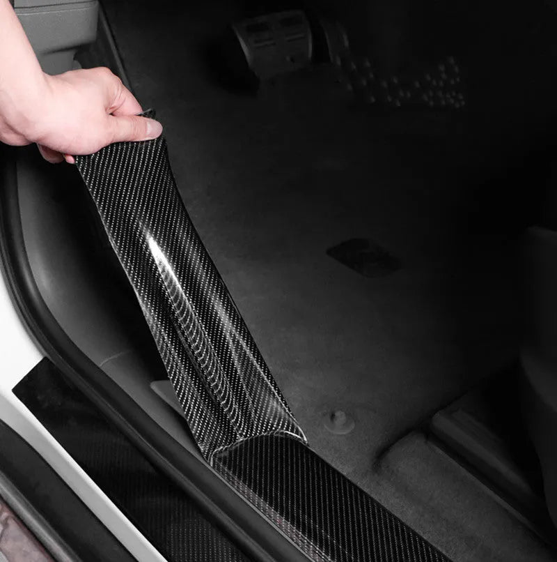 Black carbon fiber self-adhesive anti-collision decorative strip roll for car door threshold and bumper edge protection.