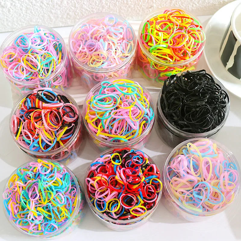 Pack of multicoloured thin TPU baby hair ties for toddlers in a reusable clear storage container.