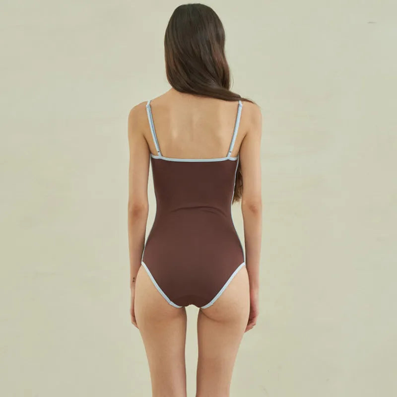 Brown women's one-piece swimsuit with a triangular style on a mannequin