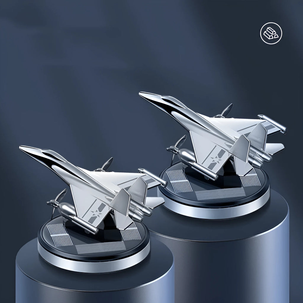 Silver solar powered rotating fighter jet perfume ornament on a car dashboard.