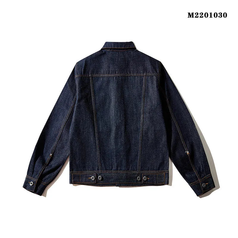Man wearing a raw pulp coloured loose Japanese-style cotton jacket with red edge trim and patch pockets.