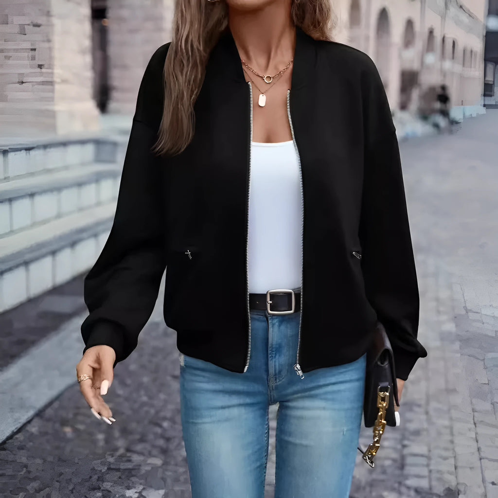 Women's solid black casual zip jacket with long sleeves, shown on a model.