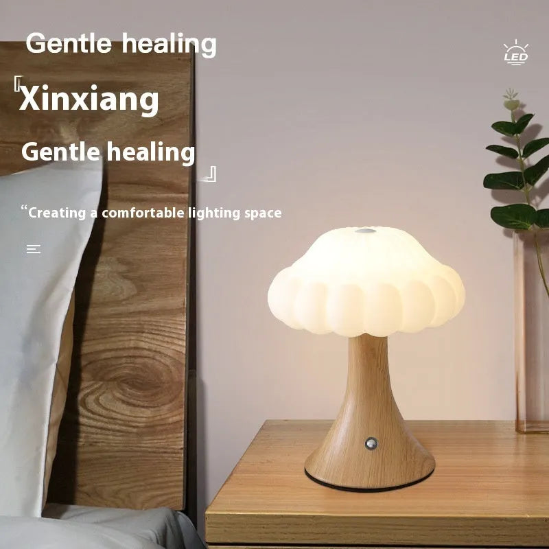 Touch control mushroom night light in wood grain colour on its wireless charging pad.