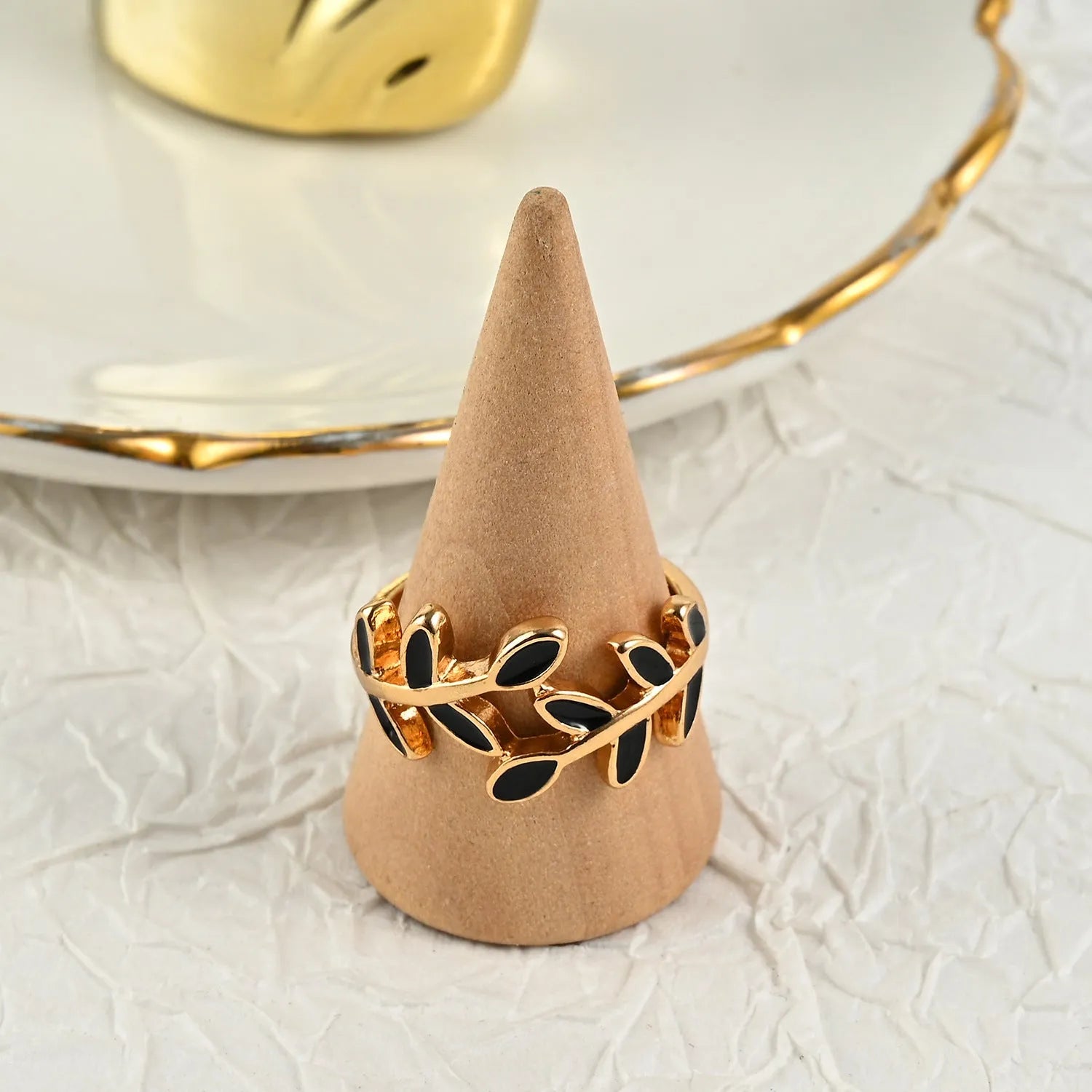 Gold geometric leaf design acrylic ring for women on a white background.