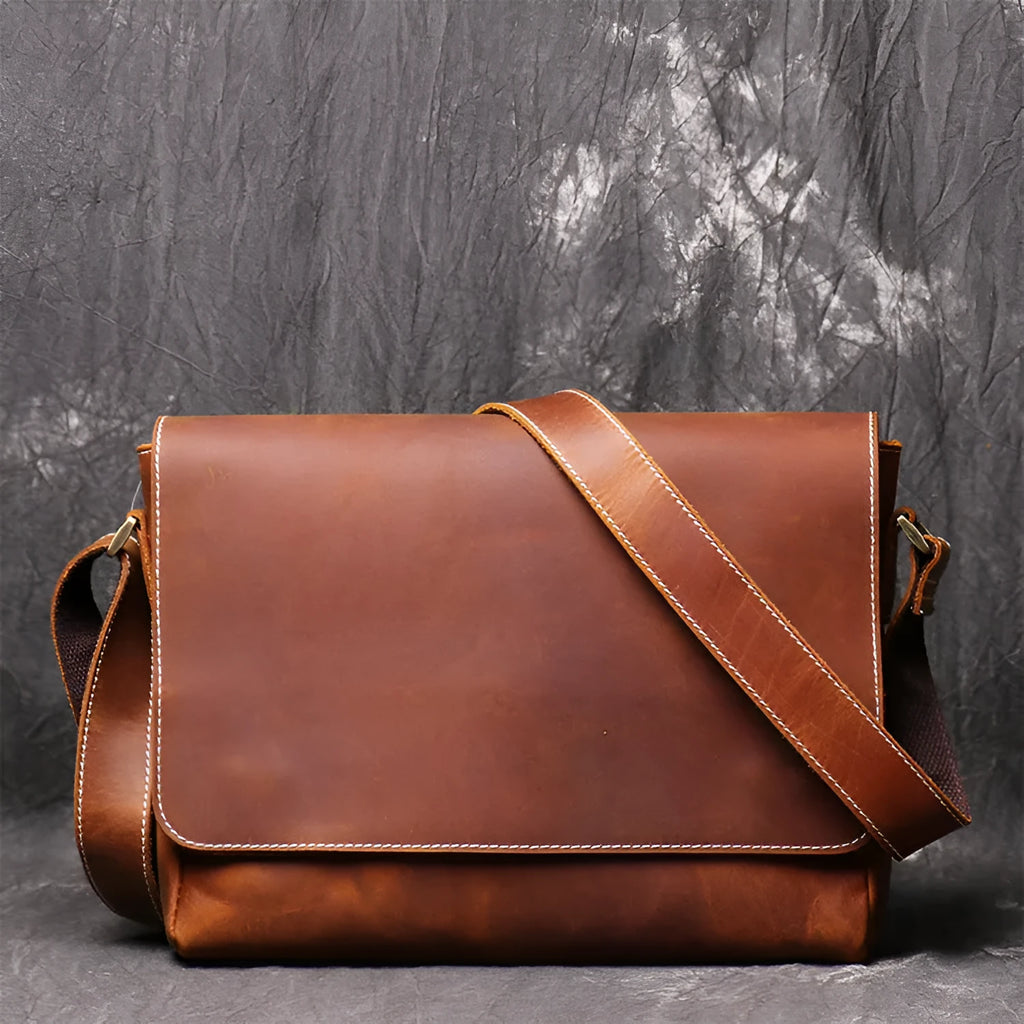 Men's vintage brown cowhide shoulder bag showing medium size and cross-body strap