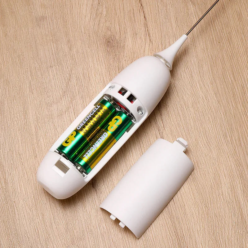 Black and white electric hand-held milk frother for coffee preparation on kitchen counter