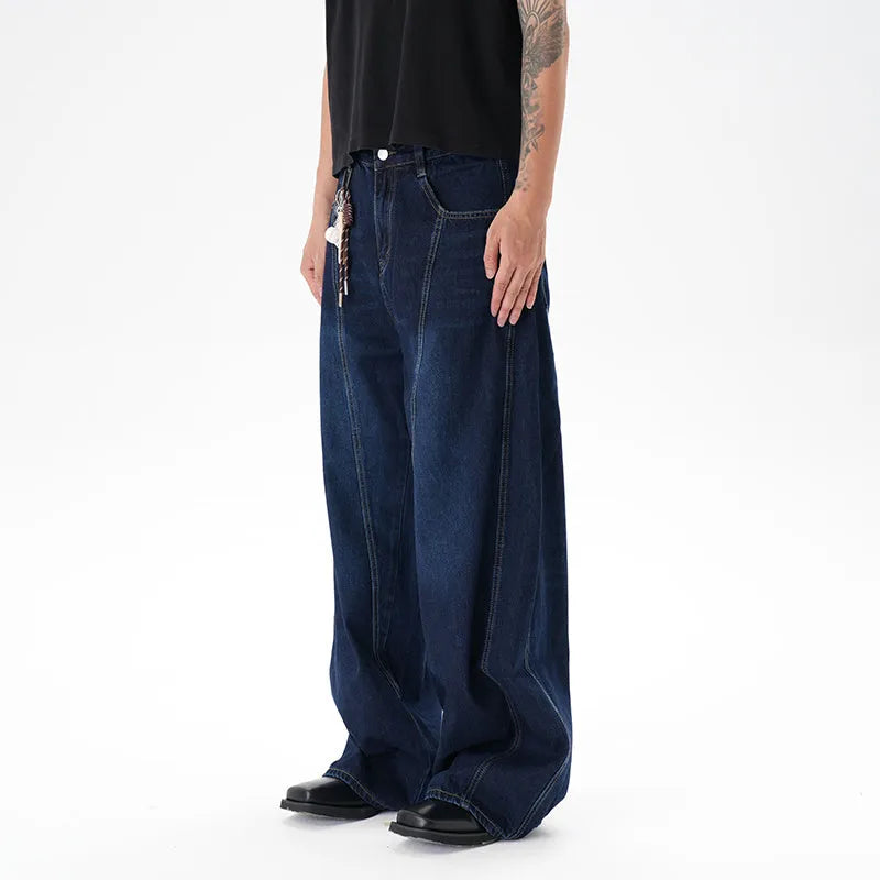 Dark blue distressed wide leg jeans with a machete cut design on a denim fabric.