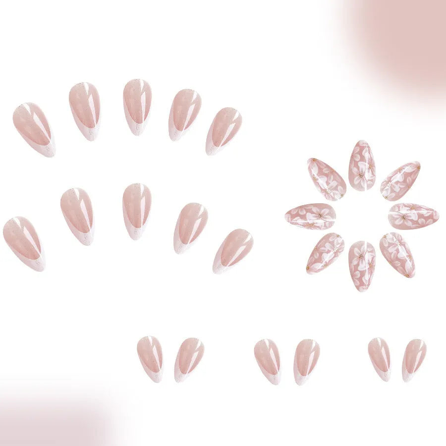 Short almond French style press-on nails with glitter accents and powder flower design on white background