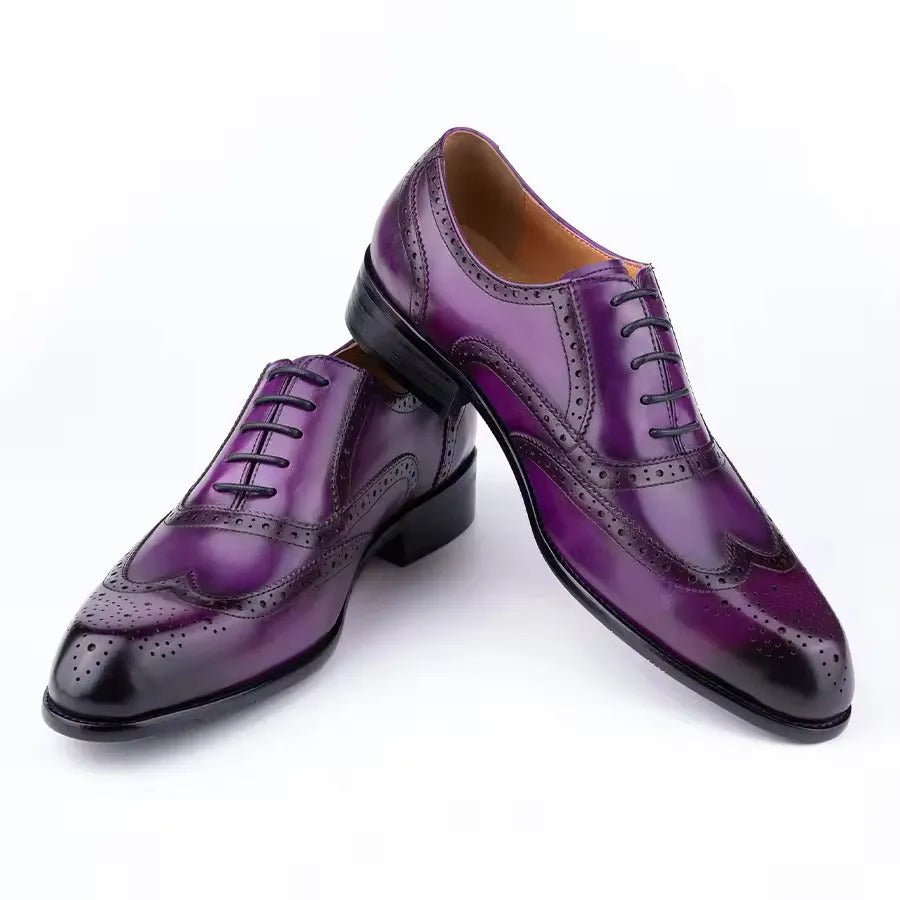 Men's purple leather oxford shoes with hand-carved detailing and a pointed toe on a rubber sole.