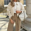 Women's apricot solid colour polyester long sleeve jacket, front view, on hanger
