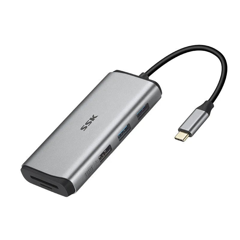 Grey 11-in-1 USB-C docking station with HDMI, VGA, USB ports, Ethernet, and card reader on a desk.