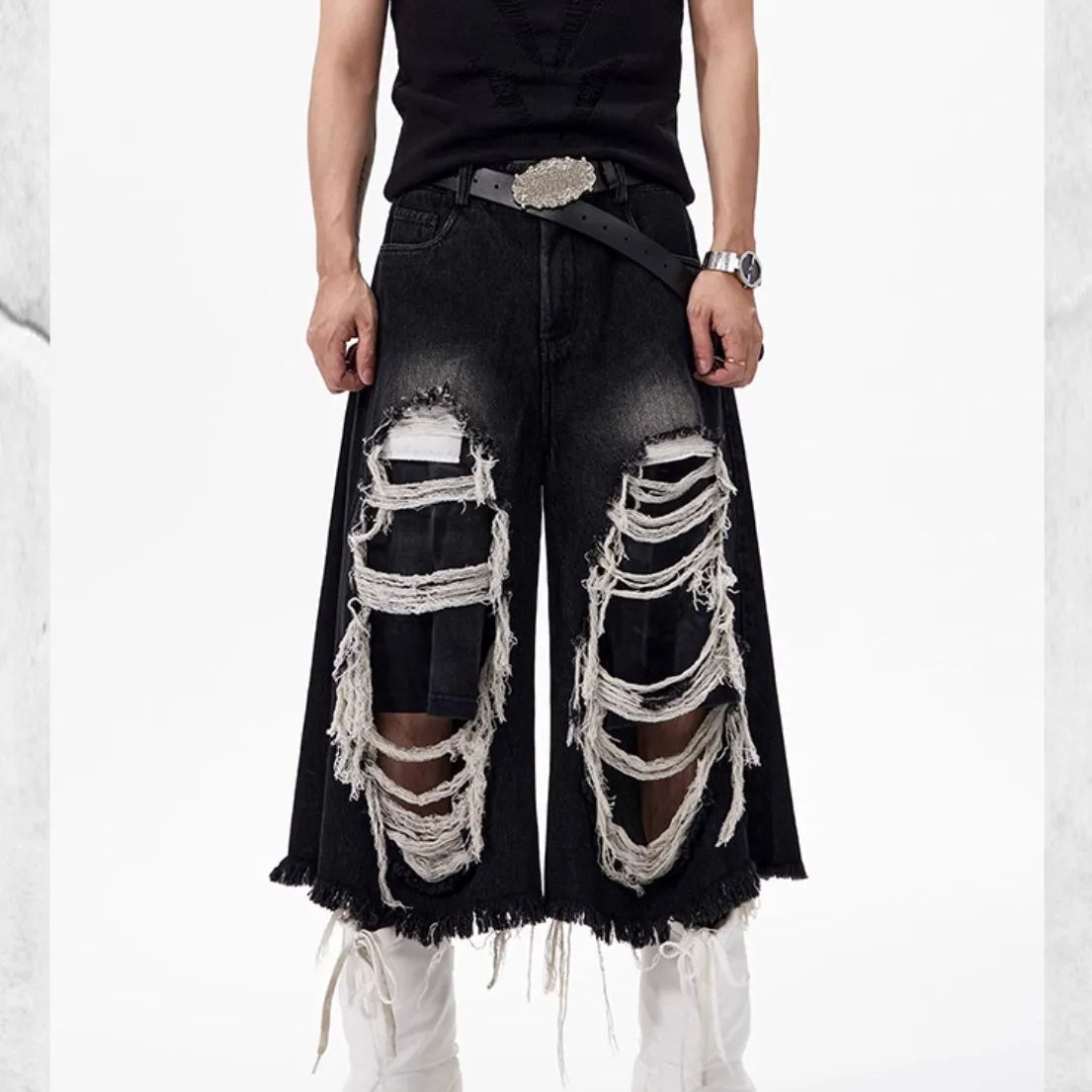 Black women's cropped wide-leg jeans with ripped patch details on the legs.