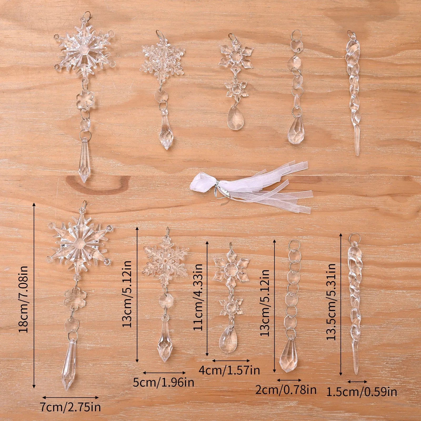 Ten clear transparent acrylic ice cone Christmas tree ornaments with white ribbons on green branches.
