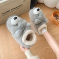 Grey ankle wrap slippers with a plush upper and a non-slip rubber sole, shown on a wooden floor.