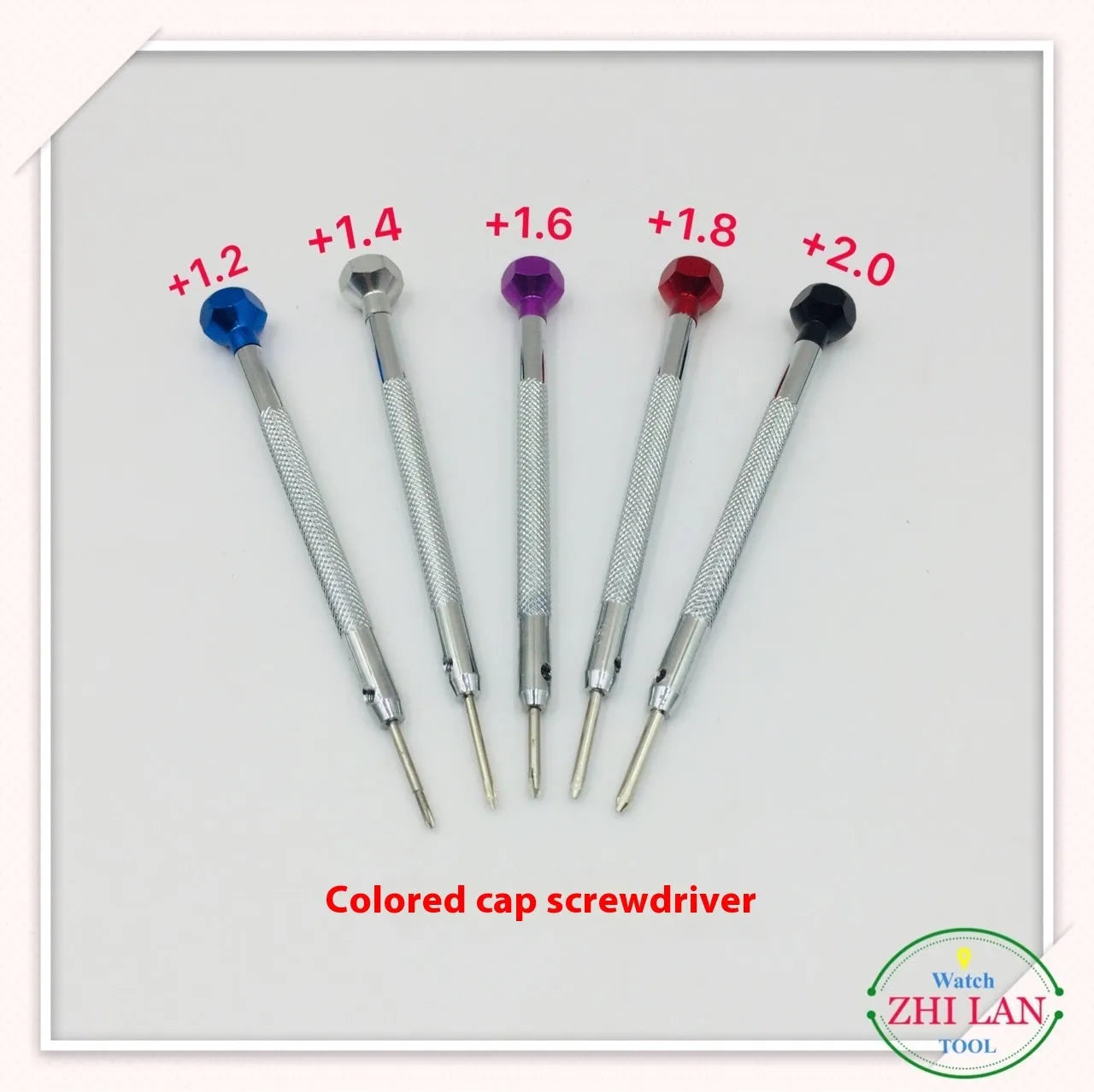 Six colour-coded watch repair screwdrivers with aluminium and copper handles laid out on a surface.