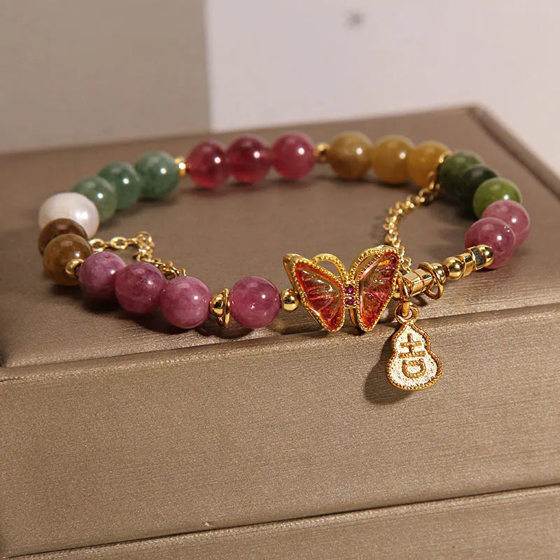 Women's agate and tourmaline bracelet with a detailed butterfly-shaped gourd charm in natural jade colours.