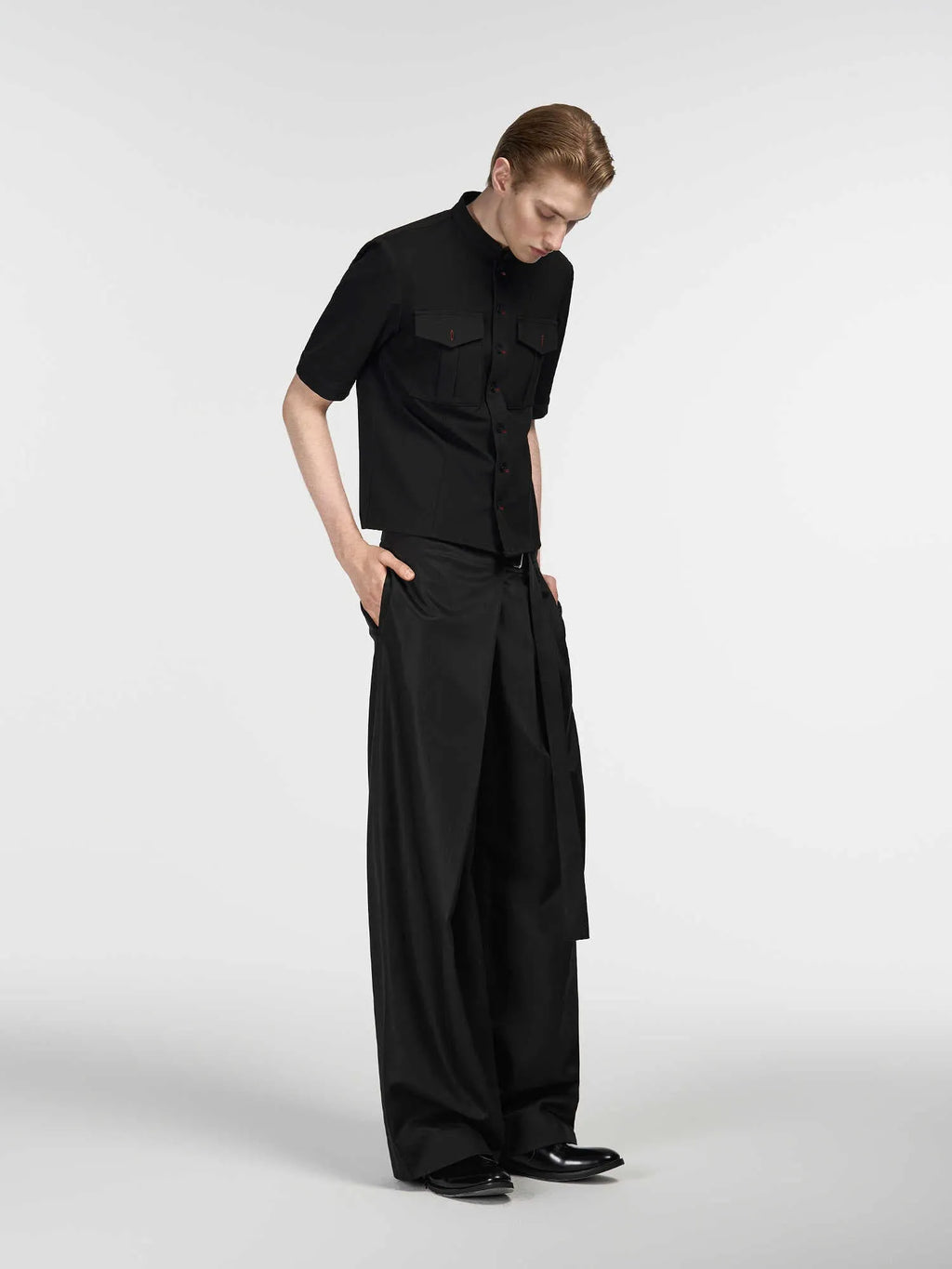 Black straight-leg trousers with a single pleat and adjustable waistband, made from a Tencel and cotton blend fabric.